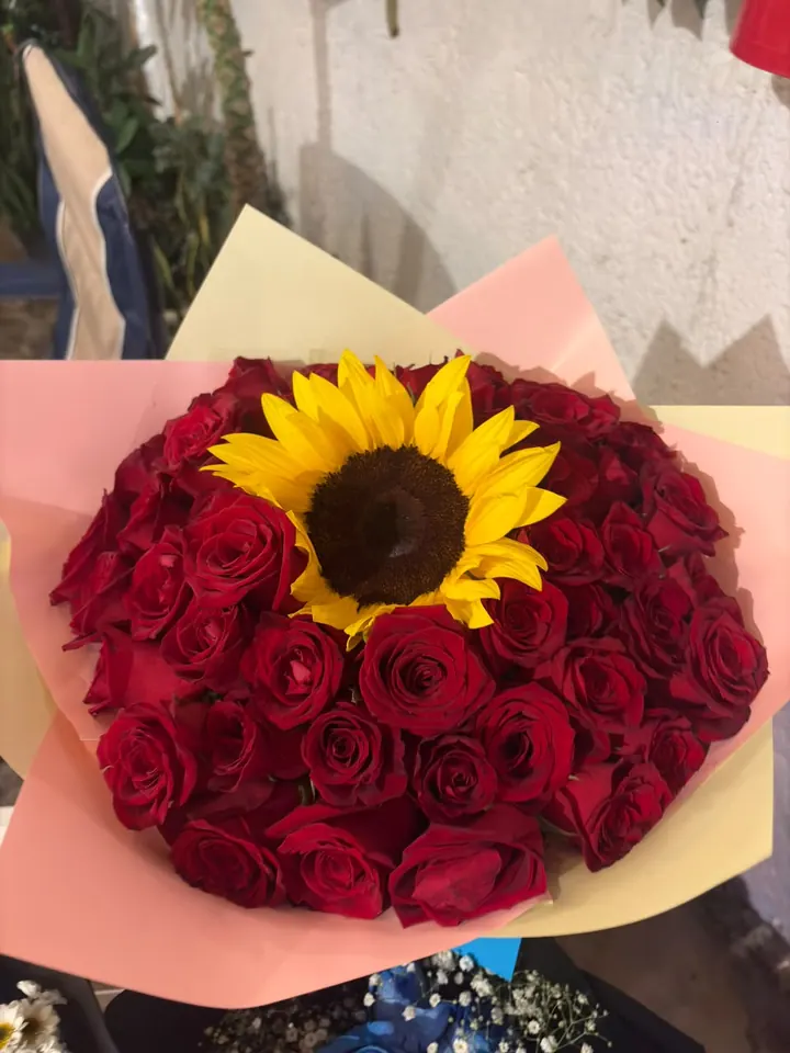 Ramo de rosas rojas con un girasol